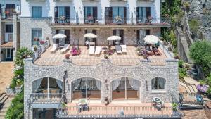 an aerial view of a building with chairs and umbrellas at Hotel Ariston and Palazzo Santa Caterina in Taormina