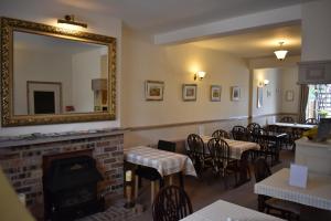 a restaurant with a fireplace and tables and a mirror at The Green Man in Leek