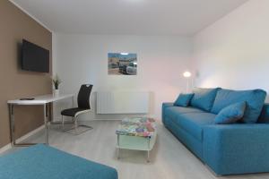 a living room with a blue couch and a table at Stax Motel in Gamstädt