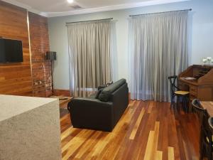 a living room with a couch and a piano at Sublime Spa Apartments in Wangaratta