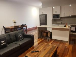 a living room with a couch and a kitchen at Sublime Spa Apartments in Wangaratta
