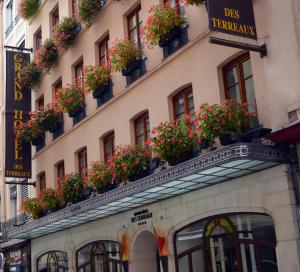 un bâtiment avec des fleurs à l'avant dans l'établissement Grand Hotel des Terreaux, à Lyon