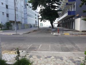 una calle vacía con una boca de incendios roja al lado de un edificio en Apartamento Guarapari, en Guarapari