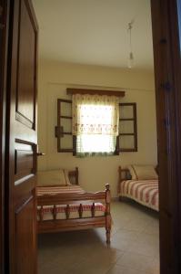 Moutsoúna的住宿－Limnes Home，一间卧室设有两张床和窗户。