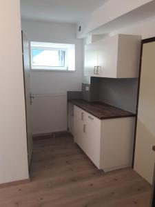 a kitchen with white cabinets and a window at Gala Apartments - Country Oasis in Pettenbach in Pettenbach