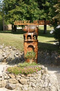 Une statue dans un parc avec un panneau. dans l'établissement Auberge du Hérisson, à La Chaux-du-Dombief