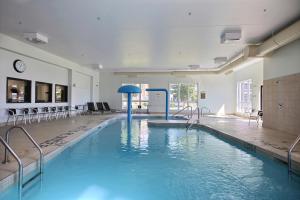 una grande piscina con acqua blu in un edificio di Super 8 by Wyndham Lachenaie/Terrebonne a Terrebonne