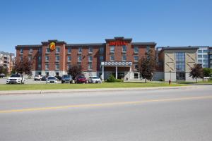 a large brick building with a hotel on a street at Super 8 by Wyndham Lachenaie/Terrebonne in Terrebonne