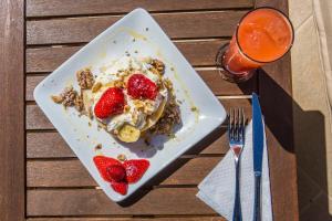 een bord dessert met aardbeien op tafel bij Seabreeze Hotel Ios in Ios Chora