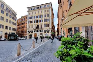 a cobblestone street in a city with buildings at Little Queen Pantheon in Rome