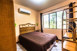 a bedroom with a bed and a window at La Dolce Vita in Esterillos