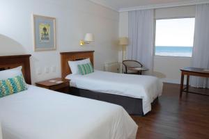 una camera d'albergo con due letti e una finestra di Lucania Palazzo Hotel a Comodoro Rivadavia Altre 30 foto
