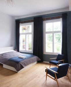 ナウェンチュフにあるAtelier Foto Lipowa - Apartamentyのベッドルーム1室(ベッド1台、椅子2脚付)