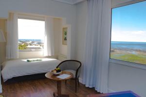 una camera da letto con un letto e una grande finestra di Lucania Palazzo Hotel a Comodoro Rivadavia