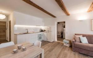 a kitchen and living room with a table and a couch at Apartment Valentina in Bressanone