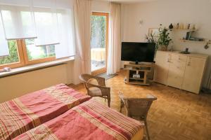 een slaapkamer met een bed en een flatscreen-tv bij Ferienwohnung Eibl in Donaustauf