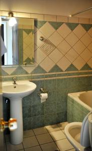 a bathroom with a sink and a mirror and a tub at Logan's Beach Hotel in Nydri