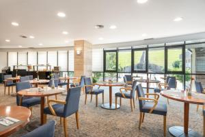 a restaurant with tables and chairs and windows at Exe Area Central in Santiago de Compostela