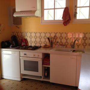 a kitchen with a white stove and a sink at Location Saint Pierre d'Oléron in La Cotinière