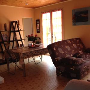 - un salon avec une table et une chaise dans l'établissement Location Saint Pierre d'Oléron, à La Cotinière