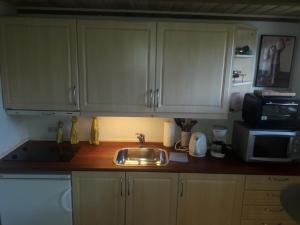 a kitchen counter with a sink and a microwave at Travel back in time in Nyord