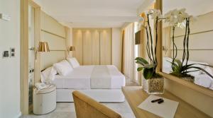 
a hotel room with a white bed and white walls at Hotel Don Pancho - Designed for Adults in Benidorm
