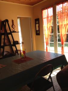 een eetkamer met een blauwe tafel en twee ramen bij Location Saint Pierre d'Oléron in La Cotinière