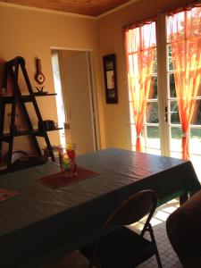 a dining room with a blue table and two windows at Location Saint Pierre d'Oléron in La Cotinière +4 photos