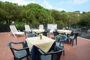 un grupo de mesas y sillas en un patio en Bike & Family Hotel Derby, en Finale Ligure