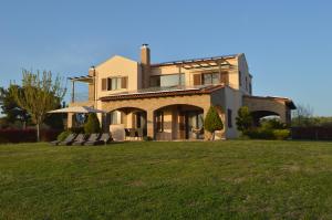 a house with a large lawn in front of it at M Varkes Villa in Nea Moudania