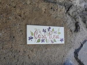 a sign on the ground with purple flowers on it at Agriturismo Cantinaccia di Sopra in Pitigliano