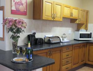 una cucina con tavolo e 2 bicchieri di vino di Butterscotch B&B a Pinetown