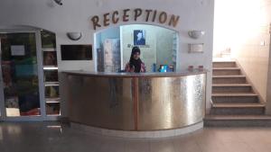 a woman standing behind a counter in a building at Razan Hotel in Amman