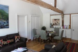 een woonkamer met een bank en een tafel en stoelen bij High Street Farm Barn in Newbury