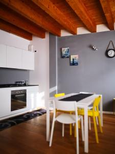 a kitchen with a white table and yellow chairs at Villa Zen 2 in Padova