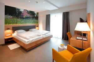 Hotel - Restaurant DAHM في Erpeldange: غرفة نوم بسرير مع لوحة على الحائط