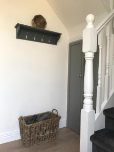 a hallway with a door and a basket on the wall at The Links Cottage in Lahinch