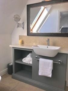 a bathroom with a sink and a mirror at The Links Cottage in Lahinch