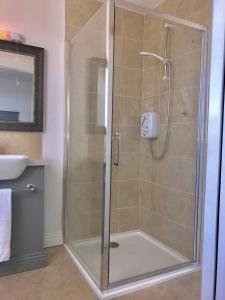 a shower with a glass door in a bathroom at The Links Cottage in Lahinch