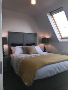 um quarto com uma cama grande e uma janela em The Links Cottage em Lahinch
