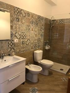 ein Badezimmer mit Toilette, Waschbecken und Dusche in der Unterkunft Etnante in Zafferana Etnea