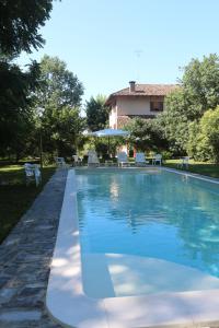 a swimming pool with chairs and a house at Locanda Del Molino Vecchio in Magliano Alfieri