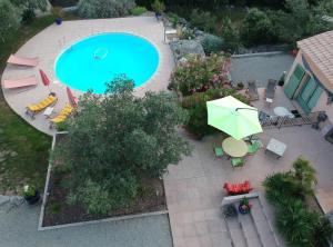 een uitzicht over een zwembad met een parasol bij Le Petit Coin de Paradis in Callas