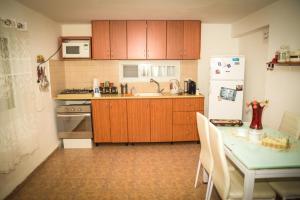 a kitchen with wooden cabinets and a table and a refrigerator at Master hosting Gal in Bet Sheʼan