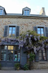 un edificio con fiori viola sulla parte anteriore di Les Mouettes a Saint-Suliac