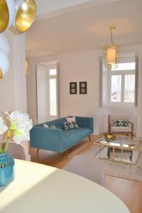 ein Wohnzimmer mit einem blauen Sofa und einem Tisch in der Unterkunft TP AURA 19, Swimming Pool, Terrace & View in Lissabon