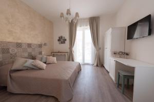 um quarto com uma cama e uma televisão na parede em Dimora dei Sogni em Civitanova Marche