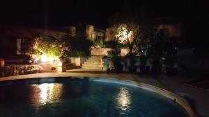 een zwembad in een tuin 's nachts bij Le Petit Coin de Paradis in Callas