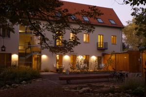 a large white house with a bench in front of it at Bio Hotel Kipperquelle in Weimar