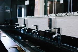 a row of sinks in a public bathroom at Lisbon South Hostel in Almada